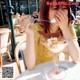 A woman sitting at a table eating an ice cream sundae.