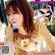 A woman sitting at a table with a bowl of ice cream.