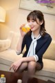 a woman sitting on a couch drinking orange juice