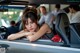 A woman sitting in the driver's seat of a car.