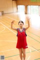 A woman in a red and blue uniform standing on a basketball court.