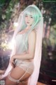 A woman with long green hair wearing a white lingerie.