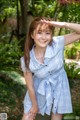 A woman in a blue and white checkered shirt posing for a picture.