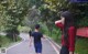 A woman in a red shirt and a man in a blue shirt are walking down the street.