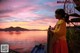 A woman standing on a boat looking at her cell phone.