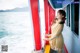 A woman in a yellow dress standing on a boat.