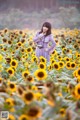 A woman standing in a field of sunflowers.