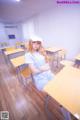 A woman sitting at a desk in a classroom.