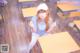 A woman sitting at a desk in a classroom.