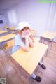 A woman sitting at a desk in a classroom.