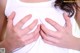 A woman holding her breasts in front of her chest.