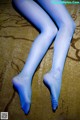 A close up of a woman's legs in blue tights.