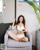 A woman sitting on a chair holding a plate of food.