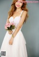 A woman in a white dress holding a bouquet of flowers.