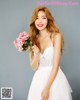 A woman in a white dress holding a bouquet of flowers.