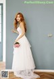 A woman in a white dress holding a bouquet of flowers.