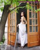 A woman standing in front of a wooden door.