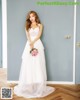 A woman in a wedding dress standing in front of a door.