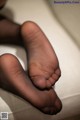 A close up of a person's feet in black pantyhose.