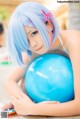 A woman with blue hair holding a blue ball.