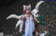 A woman dressed as a fox holding a flower in her hand.