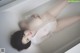 A woman laying in a bathtub with her legs up.